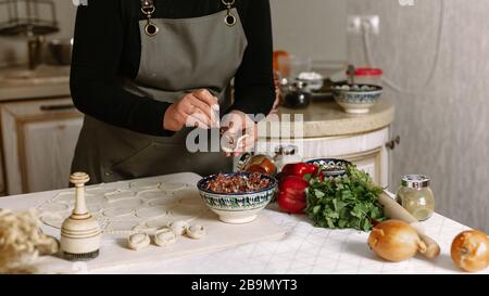 Herstellung von Knödel, Manti und Khinkali aus Hackfleisch, Lamm und Teig. Hausgemachte Speisen. Stockfoto