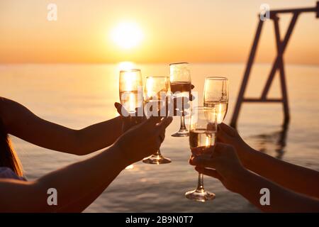 Fröhliche junge Frauen trinken Champagner auf der Junggesellen-Party am Strand. Brautpaar und Brautjungfer haben Spaß bei der Jungenparty Stockfoto