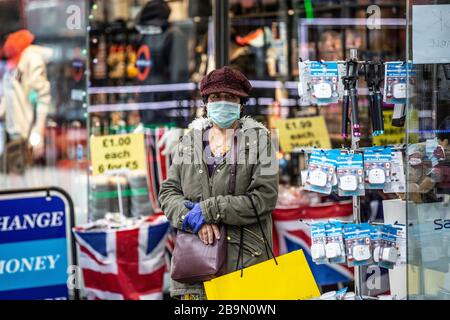 Reisende treffen Vorsichtsmaßnahmen, indem sie eine Gesichtsmaske auf der Oxford Street im West End von London gegen die Infektion des Coronavirus Covid19 Pandemie, England tragen Stockfoto