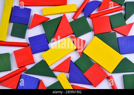 Mehrfarbiges Hintergrundbild kleiner geometrischer Holzfiguren verschiedener Farben Stockfoto
