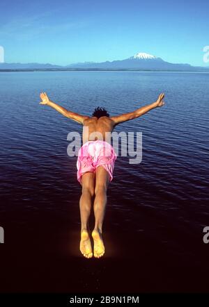 PUERTO VARAS, CHILE - DEZEMBER 1992 - junger Mann taucht in den Llanquihue-See im Lake District ein. Stockfoto