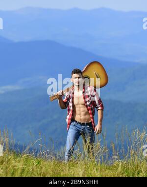 Urlaubsziele. Alleine laufen. Mann mit Gitarre auf dem Berg. Die beste Art, aus der Stadt zu entkommen. Guy Wanderer genießen reine Natur. Erkunden Sie die Natur. Schönheit der Natur. Frische Bergluft. Stockfoto