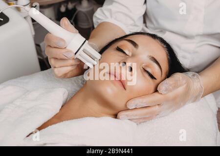 Gesichtsbehandlung gegen das Altern am Salon gegen eine kaukasische Frau Stockfoto