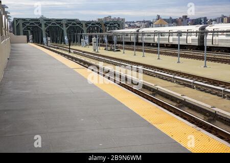 Leere U-Bahnsteige, die normalerweise um 9 Uhr morgens mit Leuten besetzt sind, die nach Manhattan fahren, während die Stadt sich für eine offizielle Sperrung bereit macht. Stockfoto