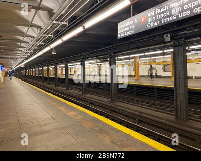 Leere U-Bahnsteige, die normalerweise um 9 Uhr morgens mit Leuten besetzt sind, die nach Manhattan fahren, während die Stadt sich für eine offizielle Sperrung bereit macht. Stockfoto