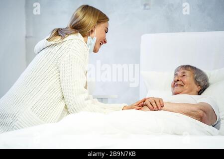 Gesundheitsversorgung im Krankenhauskonzept. Tochter besucht alte Dame im Krankenhaus Stockfoto
