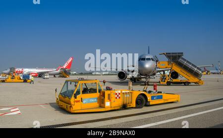 VERONA, ITALIEN - SEPTEMBER 2018: Flugzeugschlepper auf dem Vorfeld von einem Airbus-Jet geparkt Stockfoto