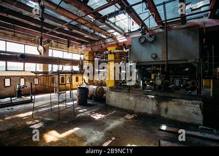 Alte rostige Industrietanks, die durch Rohre verbunden sind, die mit Ventilen in der verlassenen chemischen Fabrik verbunden sind. Stockfoto