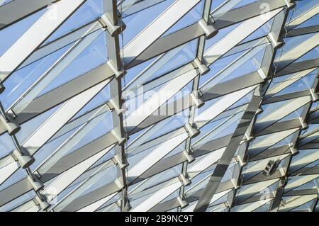Zaryad park in the center of Moscow. Triangular pattern of transparent glass of a modern roof. Rays of the evening sun illuminating the lawn. Stockfoto