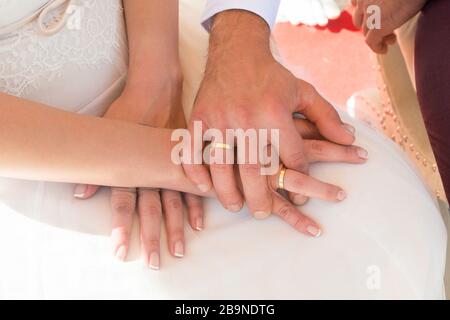 Das Brautpaar hat die Hände mit ihren Ringen. Stockfoto