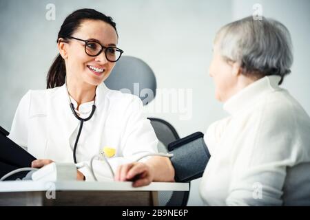 Gesundheitsversorgung im Krankenhauskonzept. Ärztin berät alte Dame Stockfoto