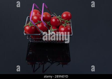 Supermarktkonzept. Frische Tomaten aus nächster Nähe. Warenkorb. Lebensmittelgeschäft. Tomaten Lieferung. Einzelhandel und Verkauf. Kirschtomaten. Stockfoto