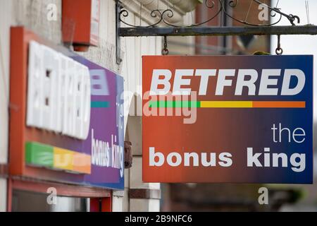 Ein Schild befindet sich über einer Filiale der Betfred Bookmakers Anthropologie Bekleidungsgeschäft in Guildford, Surrey, USA, Freitag, 20. März 2020 Stockfoto