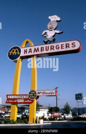 McDonald's-Schild mit dem ursprünglichen Maskottchen Speedee und großen goldenen Bögen im ältesten McDonalds Restaurant in Downey, CA Stockfoto