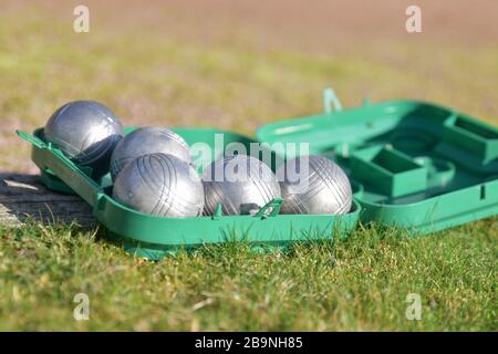 Petanque Kugeln in einer Schachtel auf dem Gras Stockfoto