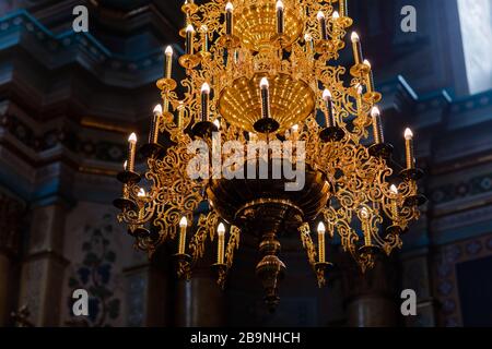 Großer Kronleuchter aus Bronze mit elektrischen Kerzen in der christlichen Domkirche. Selektiver Fokus Stockfoto