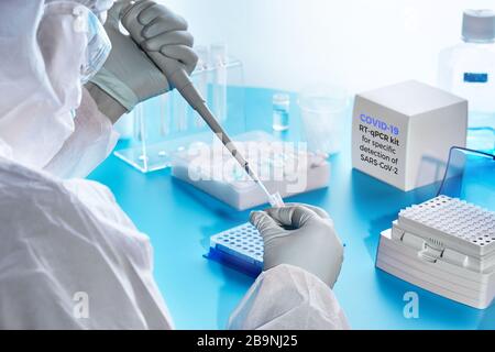 SARS-COV-2 pcr-Diagnose-Kit. Epidemiologe in Schutzanzug, Maske und Brille führt pcr-Tests durch, um eine bestimmte Region des SARS-nCoV-2-Virus zu erkennen, Stockfoto