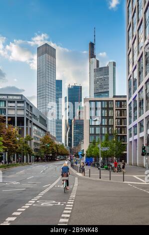 Frankfurt am Main - August 2019: Wolkenkratzer im Finanzviertel Frankfurt am klaren Sonnentag. Radfahrer fährt auf Fahrspur in lar Stockfoto