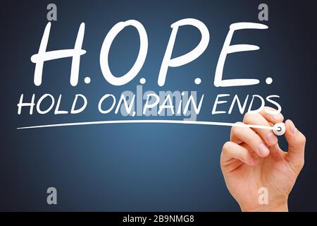 Hand, die das Akronym HOPE - Hold on Pain Ends mit weißer Markierung auf transparentem Wischbrett auf dunkelblauem Hintergrund schreibt. Stockfoto
