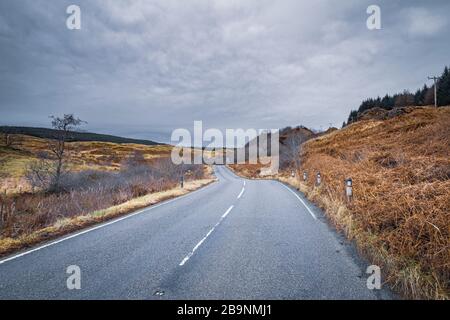 Malerische Asphaltstraße quer durch die wilde Landschaft der Westküste Schottlands Stockfoto
