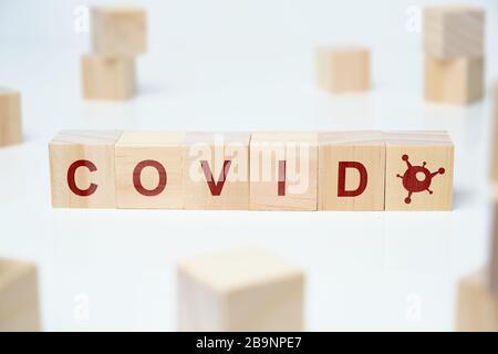 Holzklötze auf weißem Grund mit der Aufschrift - Viruskovid 19. Nahaufnahme. Stockfoto
