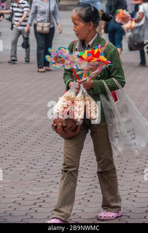 Chongqing, China - 9. Mai 2010: Außerhalb des Zoos oder Tierparks. Nahaufnahme des weiblichen ambulanten Anbieters, der Snacks und bunte Spielzeuge auf dem Platz verkauft. Stockfoto