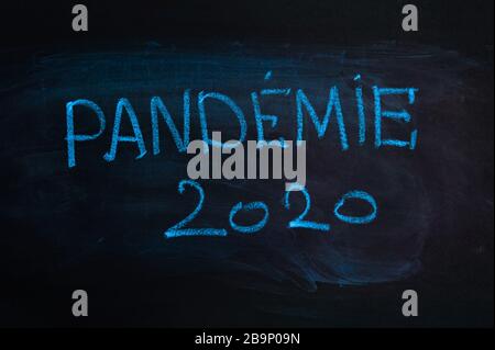 Das Wort lautet auf französisch "Pandemie". Der Text auf der Kreideplatte. Blaue Kreide Stockfoto