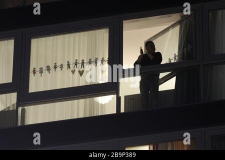 Brüssel, Belgien. März 2020. Ein Bürger lobt sich auf dem Balkon, um den Menschen, die an der Front gegen die COVID-19-Pandemie in Brüssel, Belgien, den 24. März 2020 arbeiten, Respekt zu zeigen. Kredit: Zheng Huansong/Xinhua/Alamy Live News Stockfoto