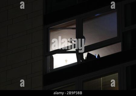 Brüssel, Belgien. März 2020. Ein Bürger lobt sich auf dem Balkon, um den Menschen, die an der Front gegen die COVID-19-Pandemie in Brüssel, Belgien, den 24. März 2020 arbeiten, Respekt zu zeigen. Kredit: Zheng Huansong/Xinhua/Alamy Live News Stockfoto