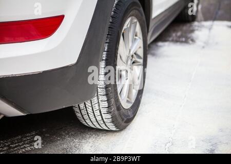 Auto auf schneebedeckter Straße rechts hinten Stockfoto