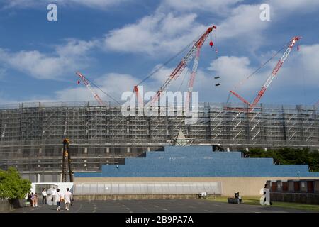 Das neue Nationalstadion erhebt sich hoch über der Umgebung, während die Vorbereitungen für die Olympischen Spiele 2020 in Tokio in Gaiemmae, Tokio, Japan, fortgesetzt werden. Stockfoto