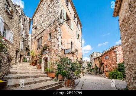 Eine malerische zurück Straße mit Geschäften und Wohnungen im mittelalterlichen Dorf Tourrettes sur Loup in der Alpes Maritimes im Süden von Frankreich. Stockfoto