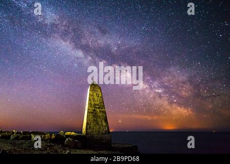 Portland Bill, Dorset, Großbritannien. März 2020. Wetter in Großbritannien. Die Milchstraße leuchtet hell im klaren Nachthimmel über dem Obelisken bei Portland Bill in Dorset. Bildnachweis: Graham Hunt/Alamy Live News Stockfoto