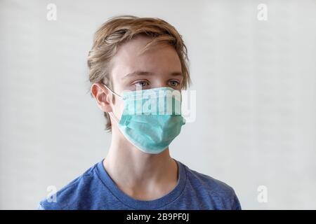 COVID-19 Coronavirus. Porträt eines 17-jährigen jungen Mannes in einer medizinischen Maske. Stockfoto