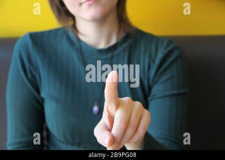 Mädchen hält Zeigefinger vor sich, zeigt auf Zuschauer und Kamera. Stockfoto