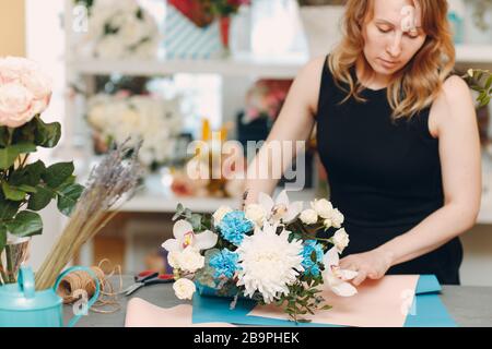 Blumenhändler macht einen Blumenstrauß in einer Blumenboutique Stockfoto
