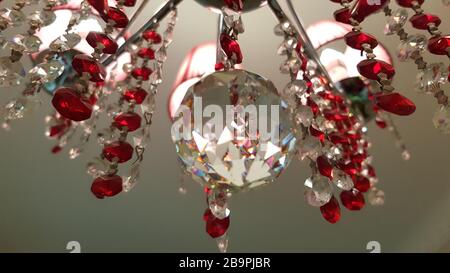 Glaskristall-Kronleuchter im Retro-Stil, von der Decke gehängt. Reflektierende Oberfläche der Kristallkugel im Nahbereich. Roter und transparenter Lampenschirm aus Glas. Zusammenfassung Stockfoto