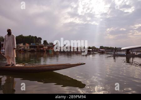 Ein Mann, der auf Shikara im Kaschmir Srinagar Dal Lake in Indien steht Stockfoto