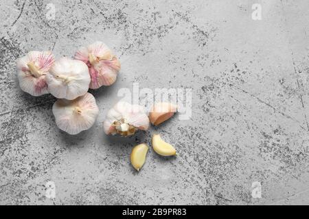 Draufsicht über Knoblauchzehen und -Birnen auf Holzschneidebrett Stockfoto