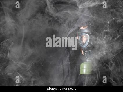 Mann in einer Gasmaske im Rauch, schwarz Stockfoto