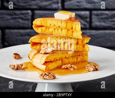 Nahaufnahme von "Hok lo Pan", Schwammpfannkuchen mit Butter, Walnüssen und Honig, serviert auf einem Kuchenständer mit schwarzer Ziegelwand im Hintergrund, Indonen Stockfoto