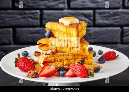 Honig wurde über einen Stapel von Brocken aus Lo-Pfanne, Schwammpfannkuchen mit Butter, Blaubeeren, Erdbeeren und Walnüssen auf einem Kuchenständer, Indon, gegossen Stockfoto