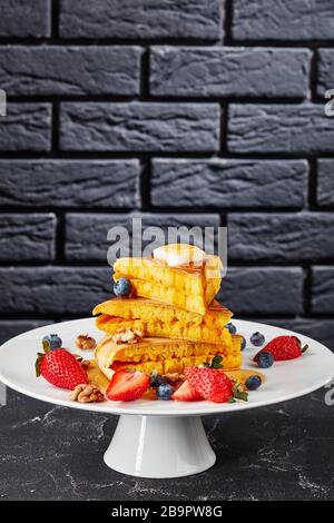 Honig wurde über einen Stapel von Brocken aus Lo-Pfanne, Schwammpfannkuchen mit Butter, Blaubeeren, Erdbeeren und Walnüssen auf einem Kuchenständer, Indon, gegossen Stockfoto