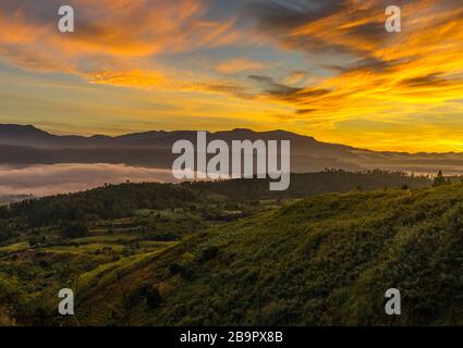 Helles goldenes Sonnenaufgangssee mit Wolken über der Stadt Blangkejeren, aber unterhalb des beeindruckenden Bukit Barisan Bergkette von Kedah aus, Banda Aceh während des wilden c Stockfoto