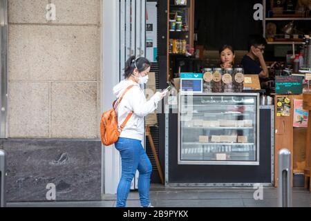 Stadtzentrum von Sydney, Australien. Mittwoch, 25. März 2020..Asian Lady mit Facemask geht an verzweifelten Café-Besitzern im Stadtzentrum von Sydney vorbei. Wir Danken Martin Berry/Alamy Live News Stockfoto