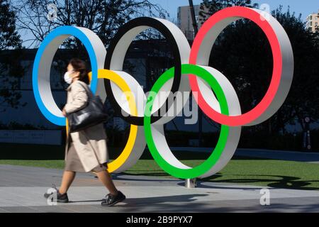 Tokio, Japan. März 2020. Eine Frau, die Gesichtsmaske trägt, spaziert am 25. März 2020 an den Olympischen Ringen in Tokio, Japan vorbei, einen Tag nach der Verschiebung der Olympischen Spiele und Paralympischen Spiele in Tokio 2020 wurde wegen des Ausbruchs des Coronavirus angekündigt. Credit: AFLO/Alamy Live News Stockfoto