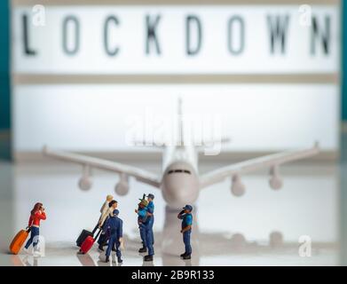 Sicherheitsflughafen-Reisebeschränkungen versperrte Konzeptbilder - kleine Spielzeugfiguren von Polizisten oder Grenzpatrouillenbeamten, die Passagiere eines Plans stoppen Stockfoto