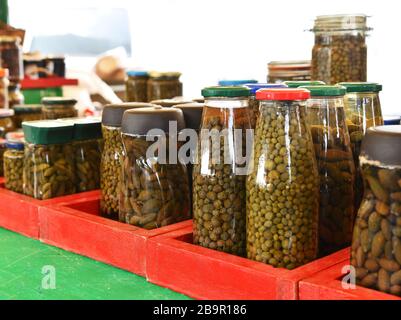 Hausgemachte eingelegte Kapern in einem Glas.eingelegte Kapern Beeren im Glas auf hellem Hintergrund isoliert. Kapern in einem Glas auf dem Markt. Eingelegte marinierte Kapern.Ma Stockfoto