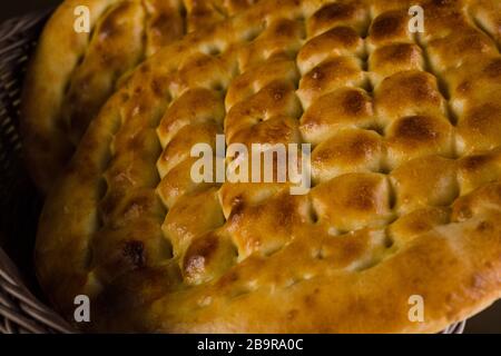 Türkisches ramazan Pidesi: Traditionelle türkische ramadan-Fladenbrote, die im ramadan-Monat gebacken werden. Blauer Stein Hintergrund. Draufsicht Stockfoto