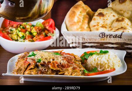Traditionelle türkische iskender Kebap Döner mit speziellen roten Sauce und Joghurt in der Mitte mit gegrillten Tomaten und Paprika Huhn garniert serviert Stockfoto